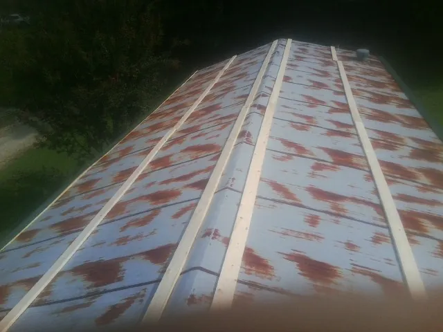 Rusted metal roof panels with new wood purlins before replacement — Storm Damage Roof Repair in Stanford by Roofing Brothers